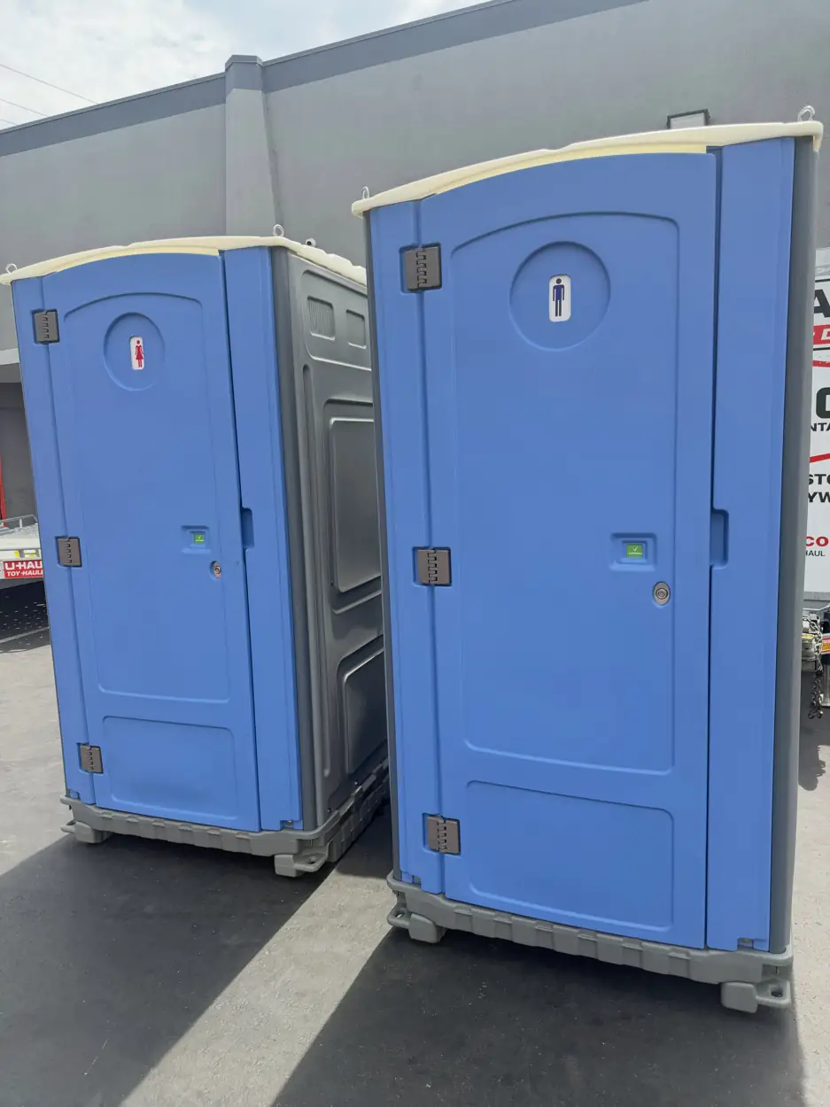Two blue standard portable toilets side by side