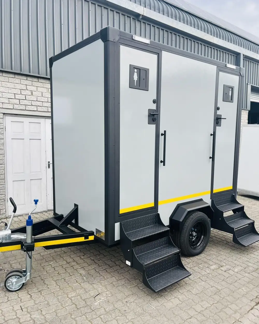 White two-stall restroom trailer with fold-down steps